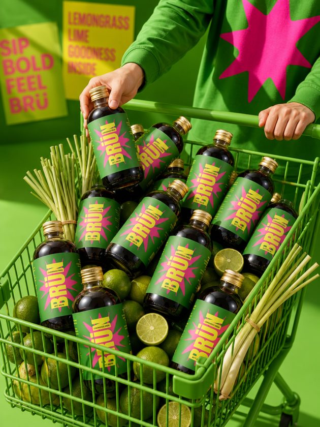 Green crate packed with BRÜN Lemongrass bottles and fresh limes