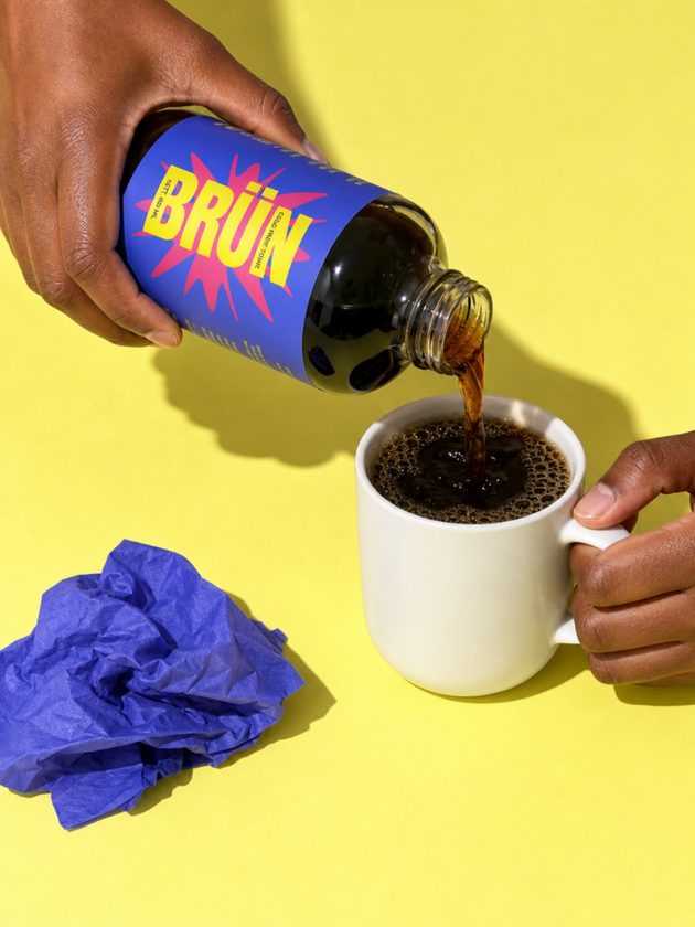 Pouring BRÜN cold brew into a white mug