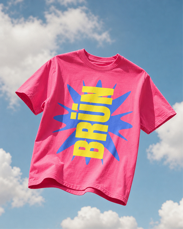 Pink BRÜN t-shirt floating against a blue sky